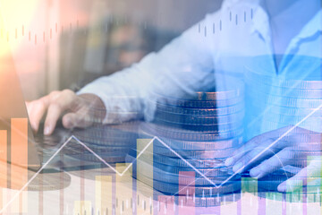 Exposing graphs and rows of coins doubling in light color for an idea of ​​using laptop data to analyze corporate financial and business growth.