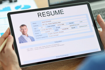 Secretary examines electronic form of man resume closeup