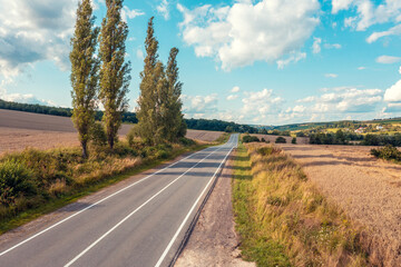 Highway through wheat fields. Summer rural landscape