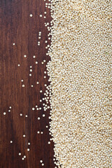 Heap of quinoa seeds scattered on wooden surface. High quality photo