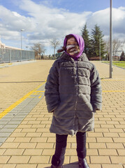 Elementary girl posing with long coat