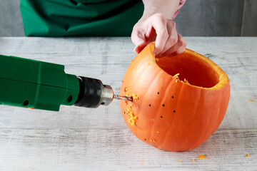 Woman shows how to transform a pumpkin into a halloween lantern
