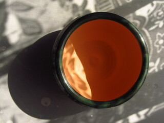 Zielona ceramiczna miska z pomarańczowym środniem - obrazy, fototapety, plakaty