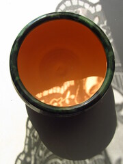 Zielona ceramiczna miska z pomarańczowym środniem - obrazy, fototapety, plakaty