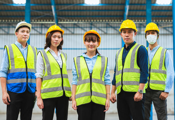 The factory employee consists of engineers, foreman, technicians, and related department staff. Wear a hard hat, and vest. Stand to pose in line looking focus at the camera. Teamwork concept.