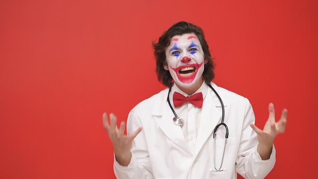 A clown doctor with colorful makeup has fun, an artistic harlequin nurse plays a show, works with children in the hospital