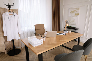 Modern medical office interior with doctor's workplace and chairs