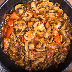Vegetable stew with mushrooms, champignons and tomatoes in a pan, top view. Vegetarian mushroom stew
