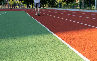 Green and red running roads and elderly runner.Morning exercises.Empty space
