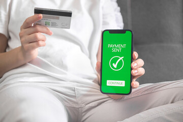 Woman sitting on sofa at home and shopping, online money transfer confirmed background photo