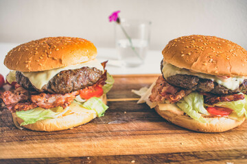 Homemade hamburger on a wooden board. Fresh juicy big burger.