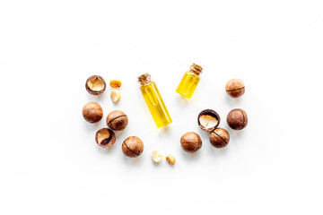 Macadamia nut oil in glass bottle with nuts. Essence extra virgin oil for food or cosmetic