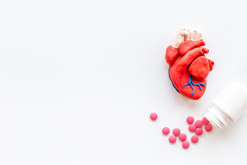 Human heart model with pills top view. Cardioigy and heart health concept