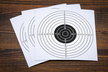 Stack of paper targets on a wooden table