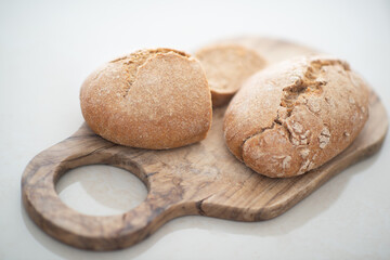 Homebaked hot appetizing bread with crispy crust sliced on wooden cutting board