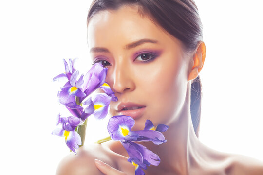 young pretty asian woman with flower purple iris isolated on white background, spa people concept