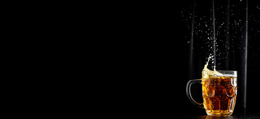 mug of beer on dark background, glass with thick foam, splashes, Long banner format