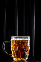 mug of beer on dark background, glass with thick foam, vertical image. place for text