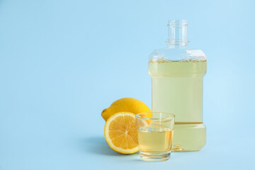 Mouthwash and fresh lemon on light blue background, space for text