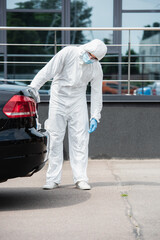Border guard in hazmat suit looking at car outdoors
