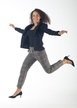 Beautiful Young Hispanic Woman Jumping And Smiling Afro Hairstyle Isolated On White Background