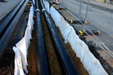 installation of hot water pipes for heating apartments. Insulated pipes are laid in the road for...