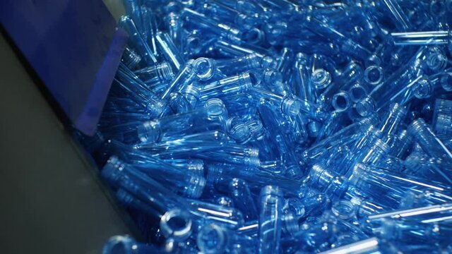 A hopper with blue reforms for blowing plastic bottles. Plant for the production of drinking and mineral water