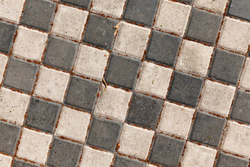 road is made of black and white concrete tiles