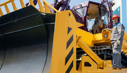 Industrial driver of yellow bulldozer gets into coal loading cab in open pit mine © Parilov