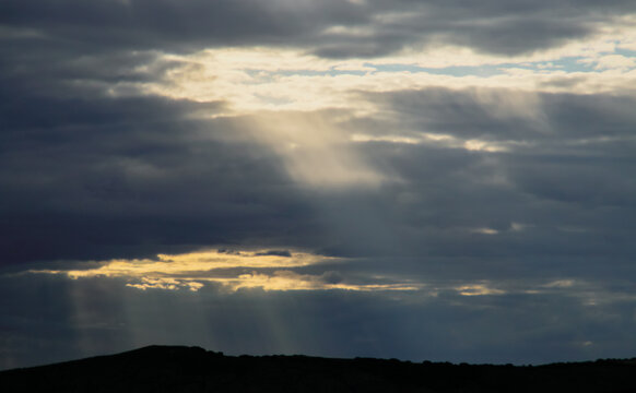 Rayos de sol en el horizonte entre las nubes. Cielo cubierto donde solo unos pocos rayos de sol atraviesan las nubes.