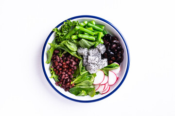 Healthy vegan salad vegetables with lettuce, corn salad, radish, kidney bean, azuki bean and green bean in a bowl on white background