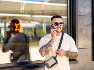 Hombre joven con tatuajes hablando por teléfono 