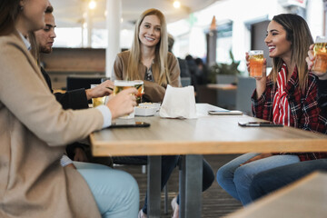 Young friends having fun together drinking beer at bar restaurant - Focus on right woman face