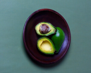 Fresh half ripe avocado on color background. Avocados are very rich in nutrients. In addition to being nutritious, avocados also have a delicious taste and are suitable for consumption by all people.