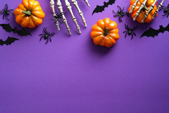 Halloween Flat Lay Composition With Pumpkins, Bony Hands, Spiders, Bats On Purple Background. Happy Halloween Banner Mockup.