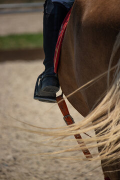 Detalle de del pie de un niño montando a caballo
