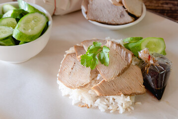 Roasted pork with streamed rice and sauce on food wrapping paper for delivery