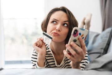 Happy young woman shopping online with credit card