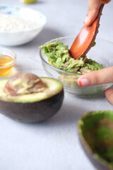 making homemade natural avocado cosmetic on table 