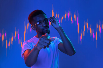Young african man pointing over purple background with trading graph in graphic concept.