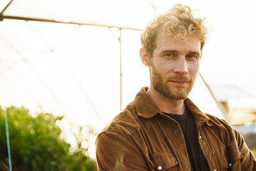 Smiling organic farmer standing in a greenhouse