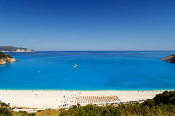 Fototapeta na wymiar Fantastic panoramic top view at Myrtos Beach with turquoise and blue Ionian Sea water. Summer scenery of famous and extremely popular travel destination in Cephalonia, Greece, Europe.