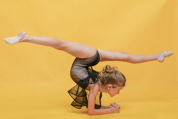 Young beautiful gymnast in sportswear performs a handstand. Workout, gymnastics element. Sports...