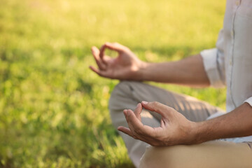 Man meditating outdoors on sunny day, closeup. Space for text