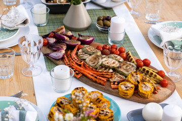 Baked vegetables and bread in the center of served table ready for outdoor lunch