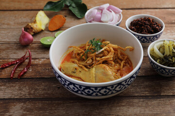 Local northern Thai food Egg noodle curry with chicken on wood background