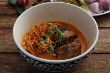 Local northern Thai food Egg noodle curry with pork ribs on wood background