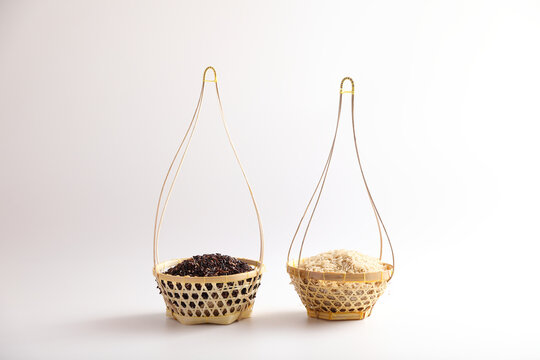 Organic raw brown rice and riceberry rice on wood basket in close up