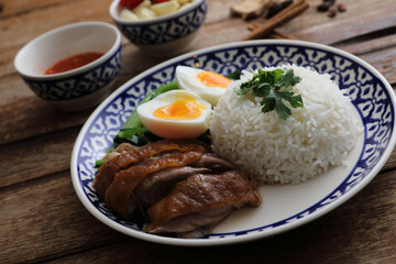 Local Thai food stewed pork leg on rice isolated in wood background