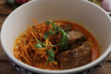 Local northern Thai food Egg noodle curry with pork ribs on wood background